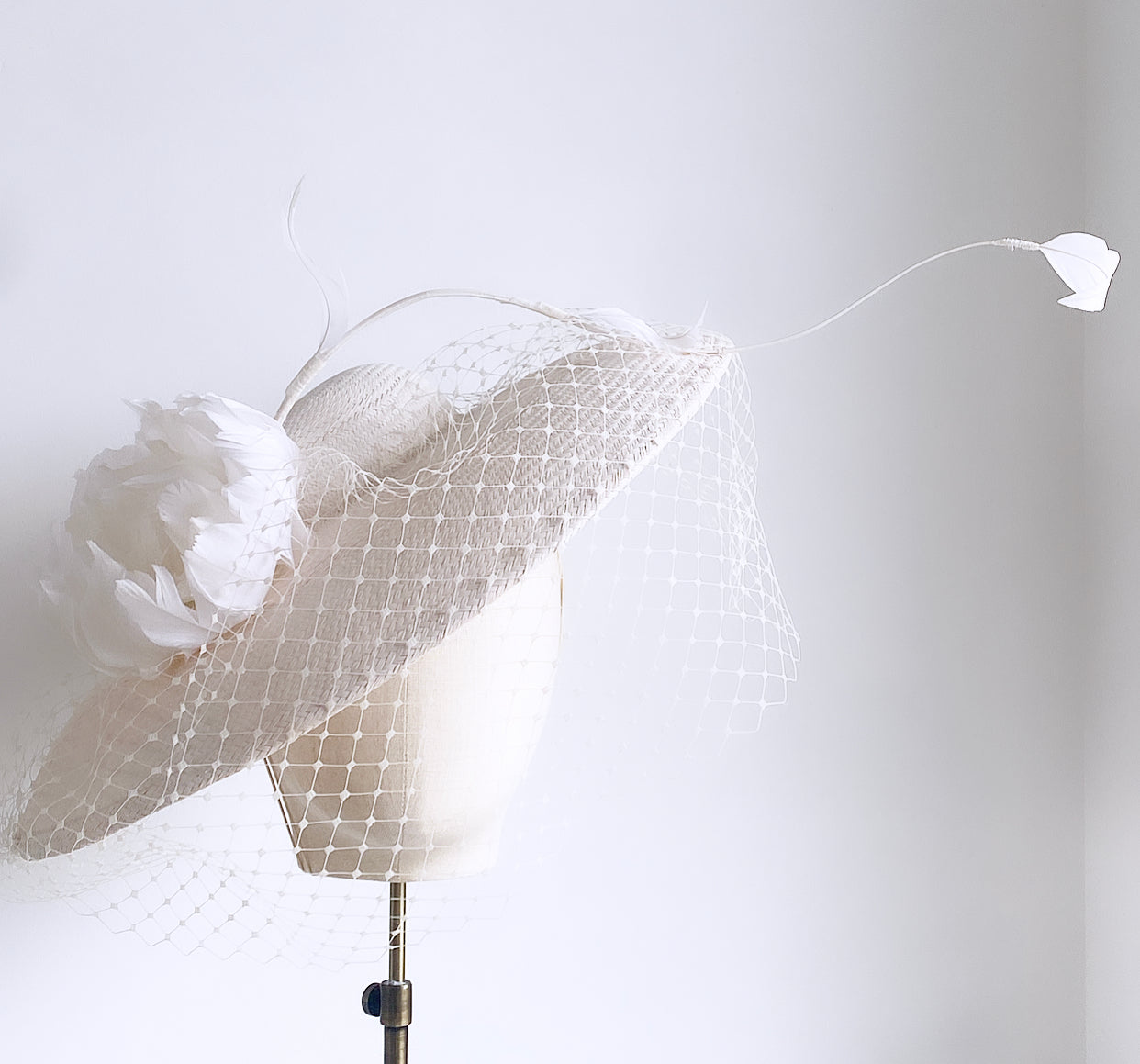 White tilt hat with feather bloom